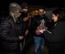 A group of people are standing next to each other in a dark room.