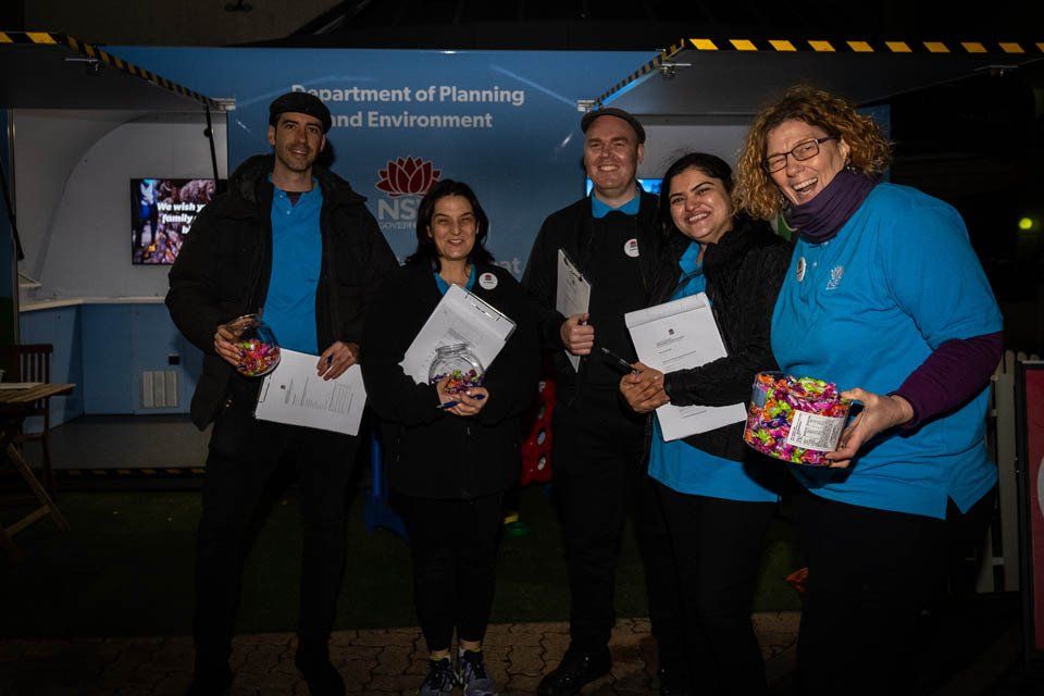 A group of people standing next to each other holding papers and candy.
