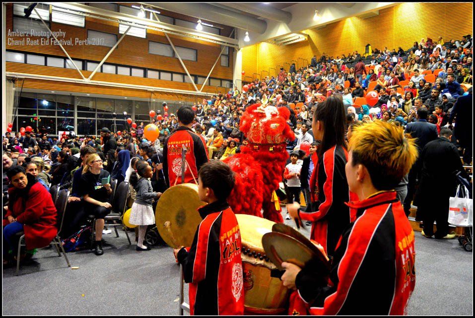 A group of people playing drums in front of a crowd