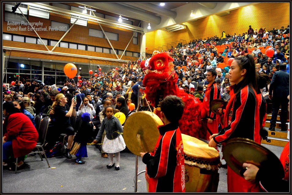A group of people playing drums in front of a crowd