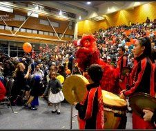 A group of people are playing drums in front of a crowd.