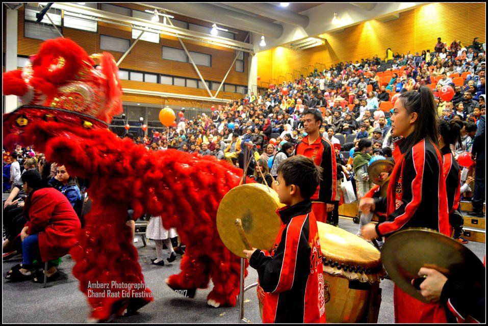 A group of people are playing drums in front of a crowd