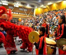 A group of people are playing drums in front of a crowd.