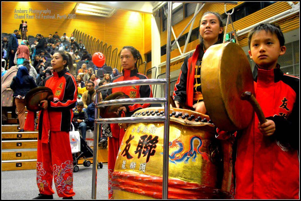 A group of people standing around a drum with chinese writing on it