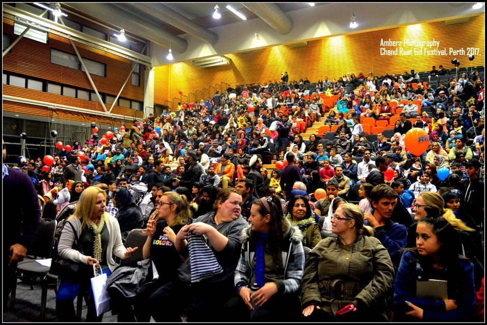 A large group of people are sitting in a large auditorium.