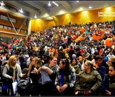 A large group of people are sitting in a large auditorium.