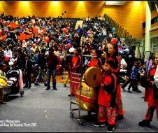 A group of people playing drums in front of a crowd