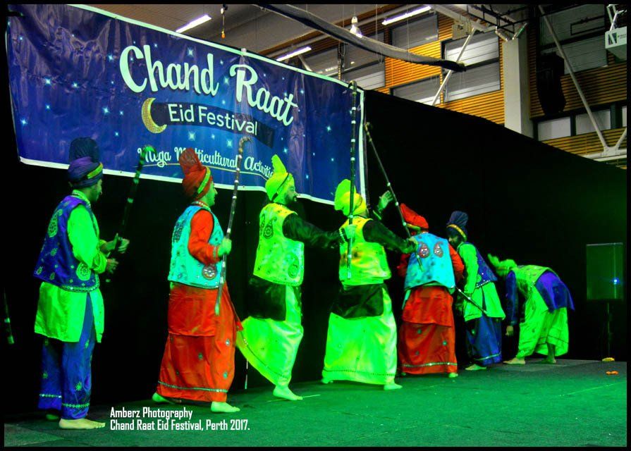 A group of people are dancing in front of a banner that says chand raat