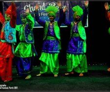 A group of people are dancing in front of a banner that says chand
