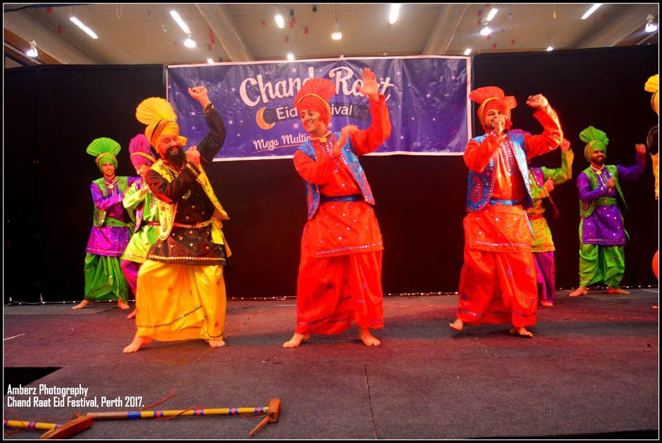 A group of people are dancing in front of a banner that says chan