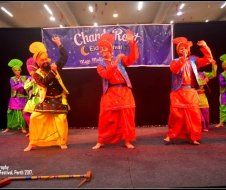 A group of people in colorful costumes are dancing on a stage.