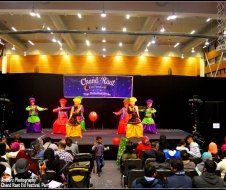A group of people are dancing on a stage in front of a crowd.