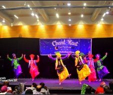 A group of people are dancing on a stage in front of a crowd.