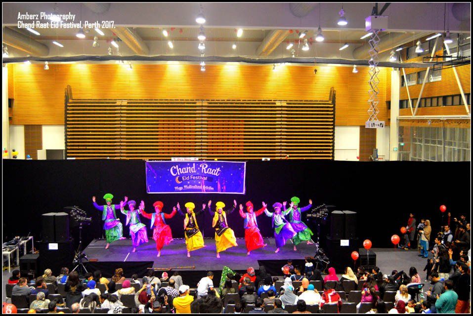 A group of people are dancing on a stage in front of a sign that says craft fair