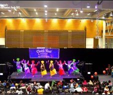 A group of people are dancing on a stage in front of a crowd.