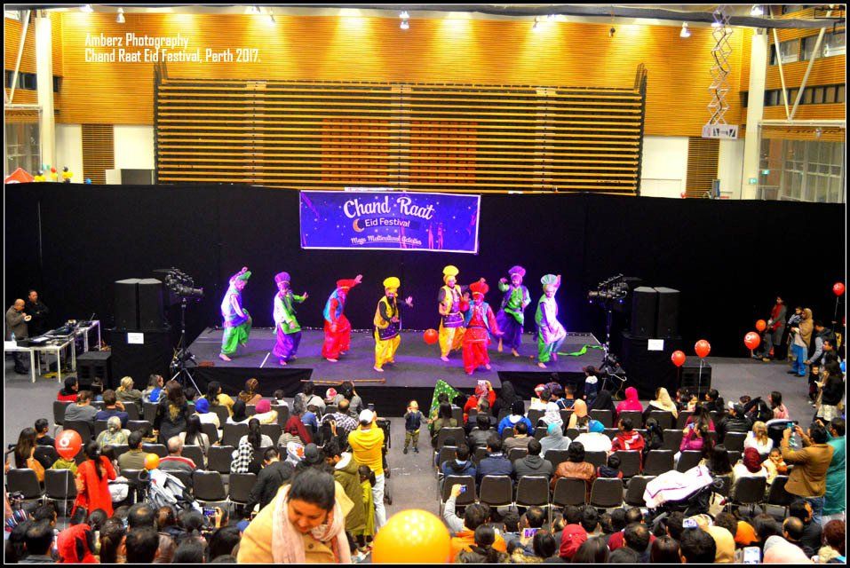 A group of people are dancing on a stage with a sign that says ' world peace ' on it