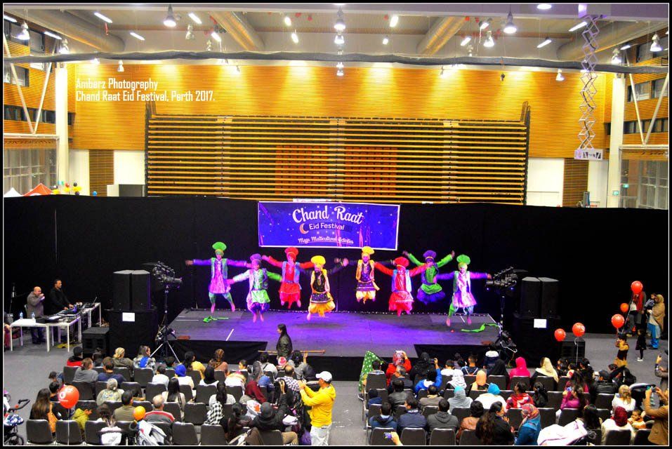 A group of people are dancing on a stage with a sign that says david king