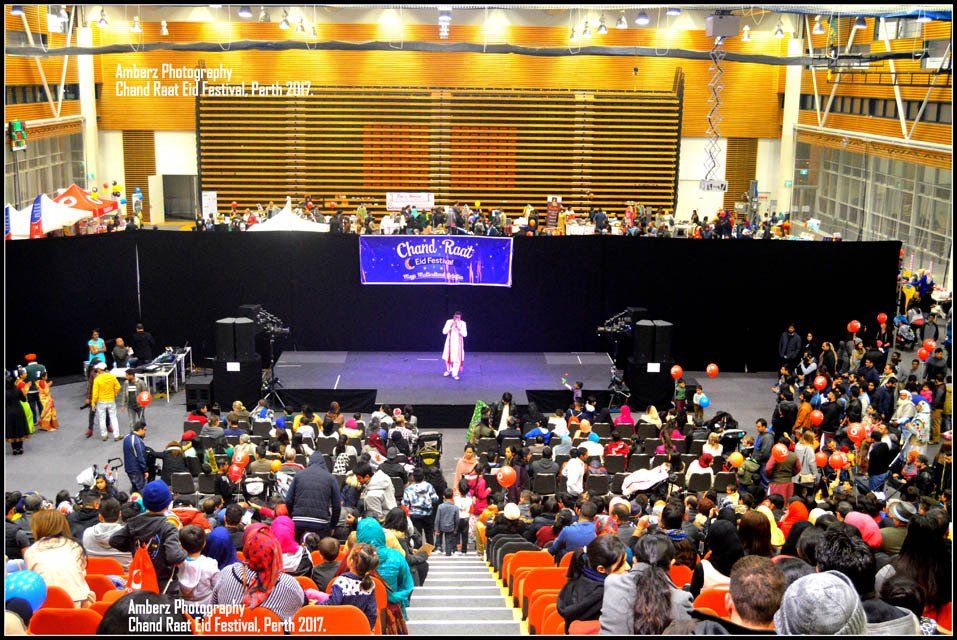 A large crowd of people are gathered in a large auditorium