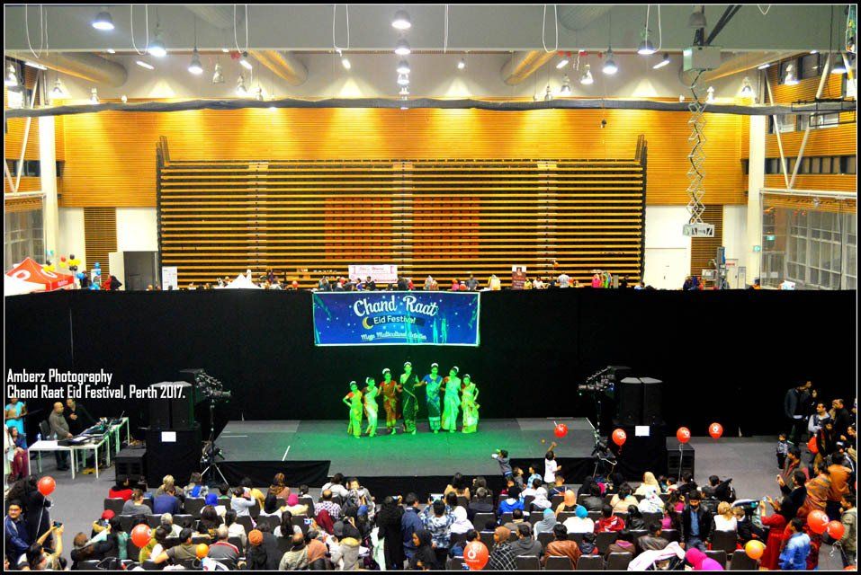 A group of people standing on a stage in front of a sign that says classical dance