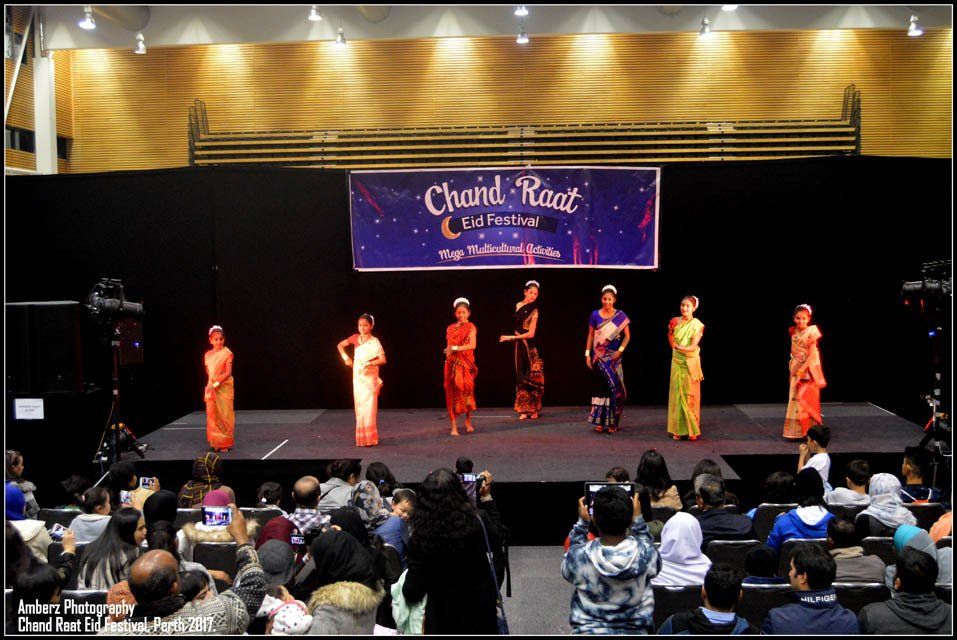 A group of women are standing on a stage in front of a sign that says ' grand race '