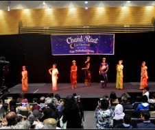A group of women are dancing on a stage in front of a crowd.