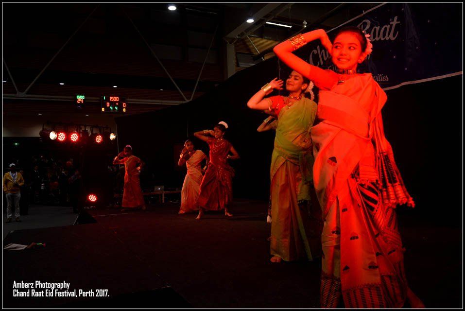 A group of women are dancing in front of a sign that says rat