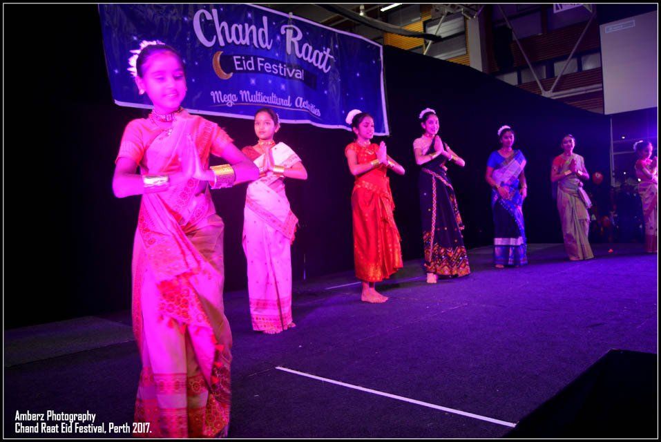 A group of women are dancing in front of a banner that says chand raat