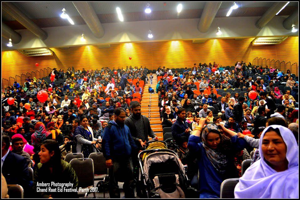 A large crowd of people are sitting in a large auditorium