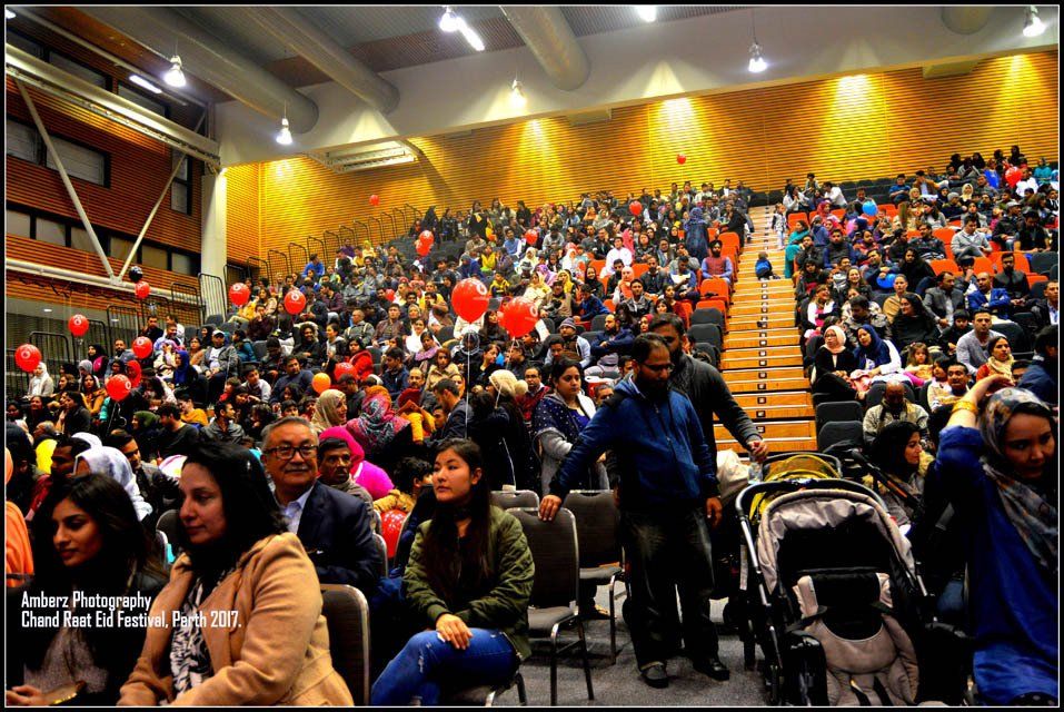 A large crowd of people are sitting in an auditorium