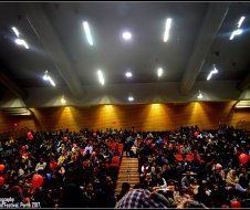 A large crowd of people are sitting in a large auditorium.