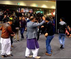 A group of men are dancing in front of a crowd.