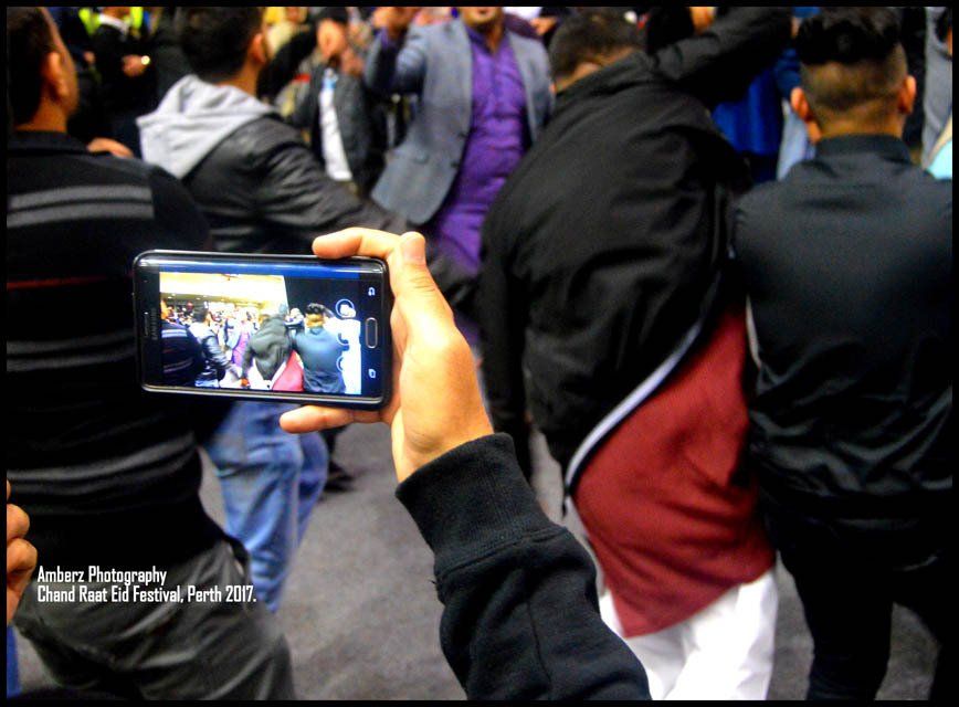 A person is taking a picture of a crowd with a cell phone