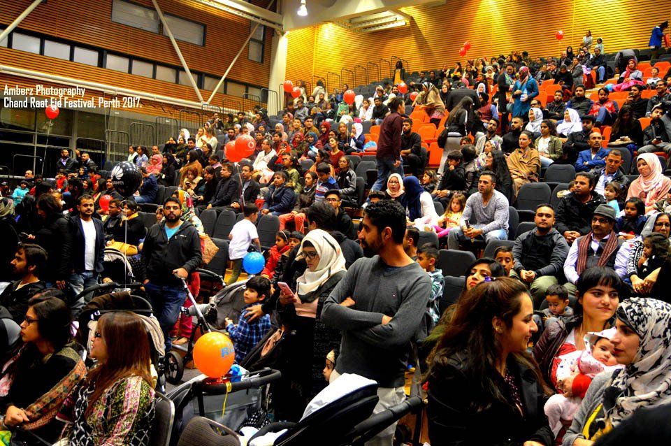 A large crowd of people are sitting in an auditorium