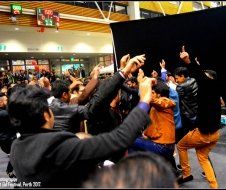A group of people are standing in front of a black curtain.