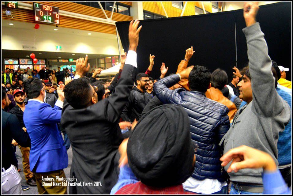 A group of people are raising their hands in the air