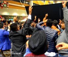 A crowd of people are raising their arms in the air.