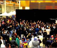 A large crowd of people are gathered in front of a stage.