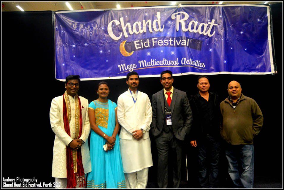 A group of people standing in front of a banner that says chand raat