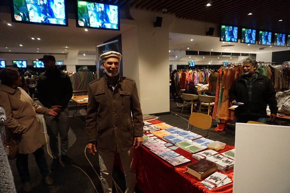 A man is standing in front of a table in a store.