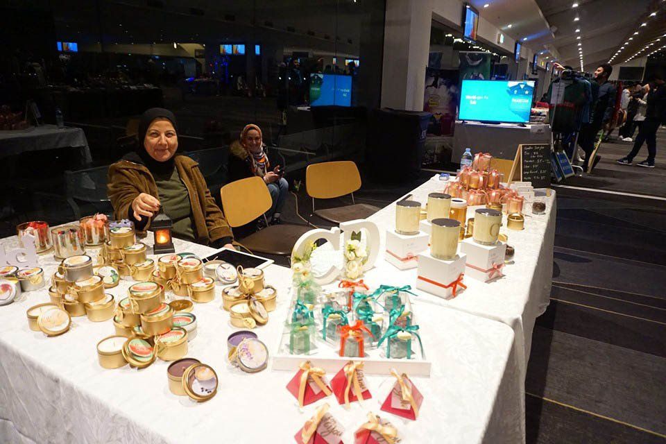 A woman is sitting at a table with candles on it.