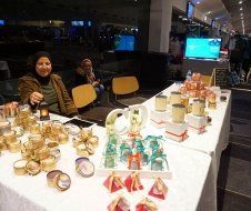 A woman is sitting at a table with candles on it.