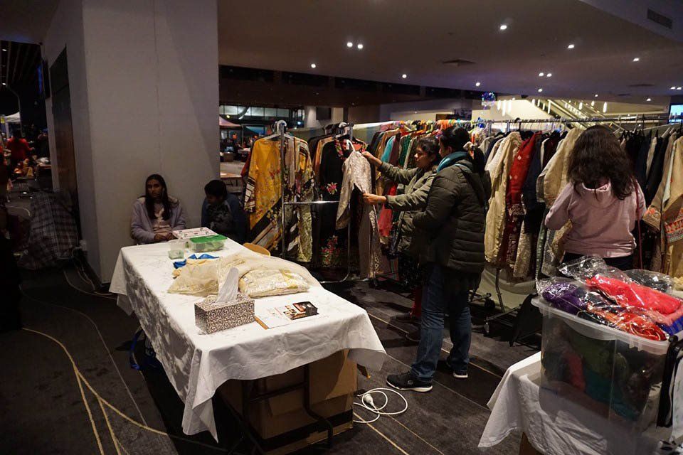 A group of people are shopping at a clothing store.