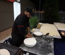 A man is preparing food in bowls on a table.