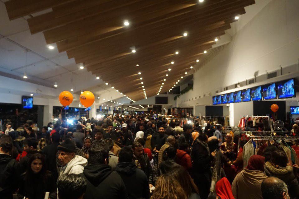 A large crowd of people are gathered in a large room.