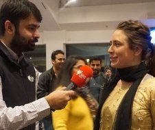 A man is holding a microphone and talking to a woman.