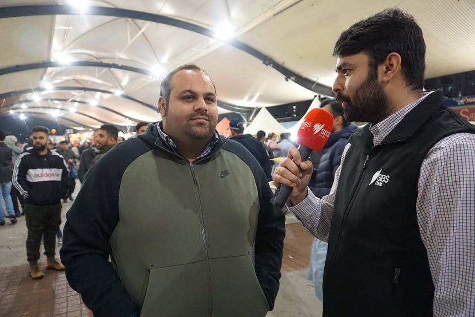 A man is being interviewed by another man with a microphone.