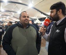 A man is being interviewed by another man with a microphone.