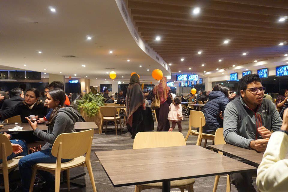 A group of people are sitting at tables in a restaurant.