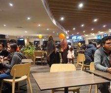 A group of people are sitting at tables in a restaurant.