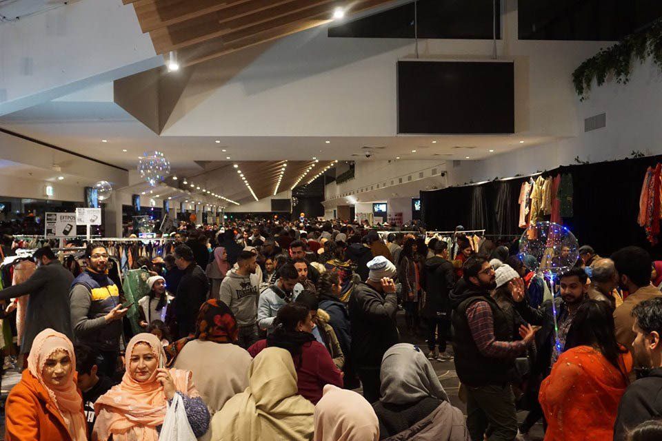 A large group of people are standing in a store.